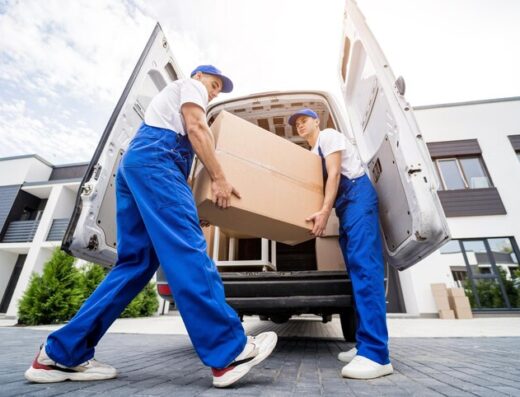 Two removal company workers unloading boxes furniture from minibus 179755 16638