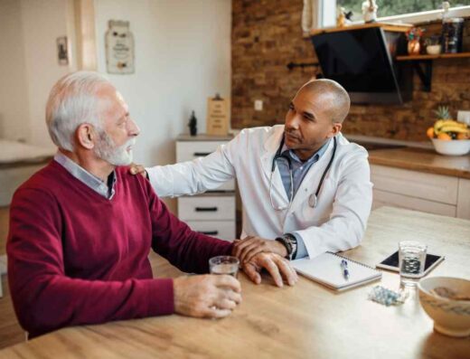 African american doctor talking senior man home visit (1)